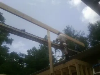 Carpenter setting a ridge beam over a new addition frame — Ice Dam Removal by Roofing Brothers in California